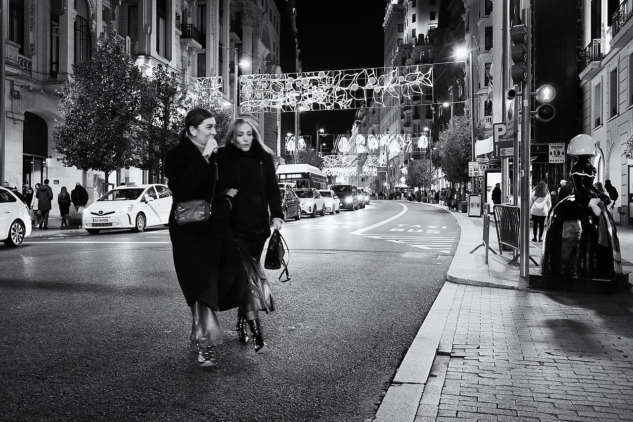 Gran Vía de Madrid con viandantes y edificios iluminados